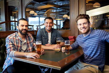 Image showing happy male friends drinking beer at bar or pub