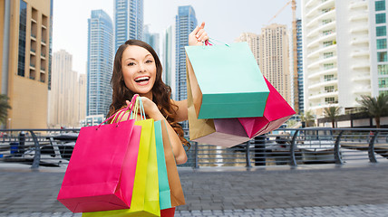 Image showing happy woman with shopping bags over dubai city