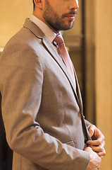 Image showing close up of man trying suit at clothing store