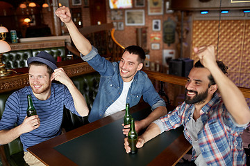 Image showing happy male friends drinking beer at bar or pub