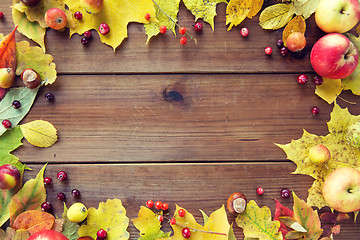 Image showing frame of autumn leaves, fruits and berries on wood