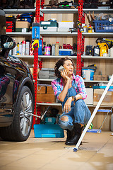 Image showing mechanic in an auto repair shop talking on mobile