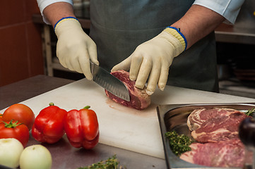 Image showing Chef cutting meat