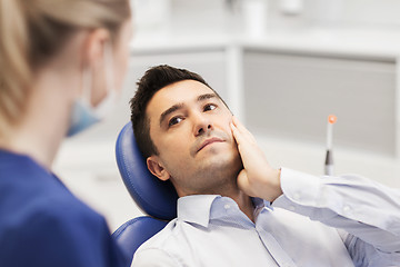 Image showing female dentist and male patient with toothache