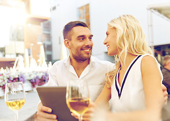 Image showing happy couple with tablet pc at restaurant terrace