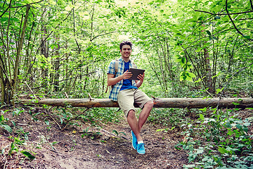 Image showing happy man with backpack and tablet pc in woods