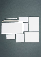 Image showing Mock-up business template with cards, papers, pen. Gray background.