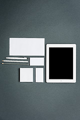 Image showing Mock-up business template with cards, papers, tablet. Gray background.