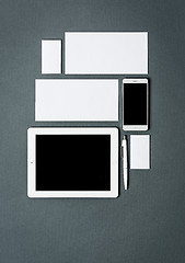 Image showing Mock-up business template with cards, papers, tablet. Gray background.