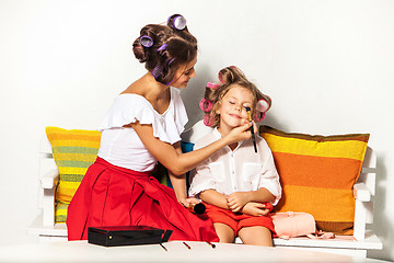 Image showing Little girl playing with her mom\'s makeup