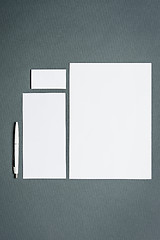 Image showing Mock-up business template with cards, papers, pen. Gray background.