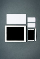 Image showing Mock-up business template with cards, papers, tablet. Gray background.