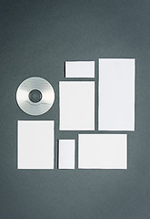 Image showing Mock-up business template with cards, papers, disk. Gray background.