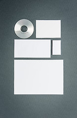 Image showing Mock-up business template with cards, papers, disk. Gray background.