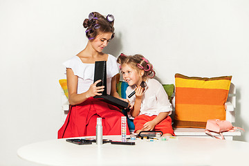 Image showing Little girl playing with her mom\'s makeup