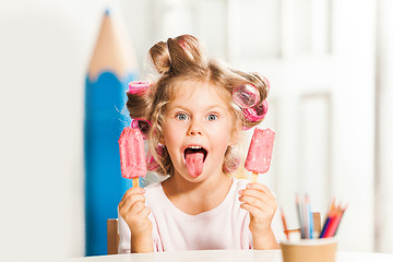 Image showing Little girl sitting and eating ice cream