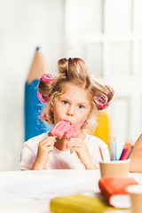 Image showing Little girl sitting and eating ice cream