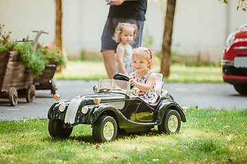 Image showing The little baby girl playing at car