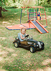 Image showing The little baby girl playing at car