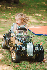 Image showing The little baby girl playing at car