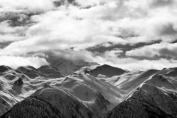 Image showing Black and white view on snowy mountains and cloudy sky at evenin