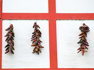 Image showing Red Wooden wall and dry peppers