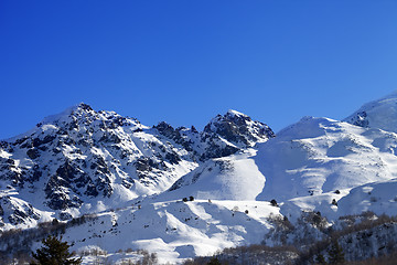 Image showing Snowy mountains and off-piste slope on sunny day