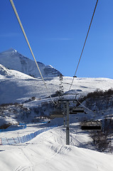 Image showing Chair-lift at ski resort in sun winter morning