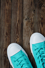 Image showing blue sneakers on wooden surface