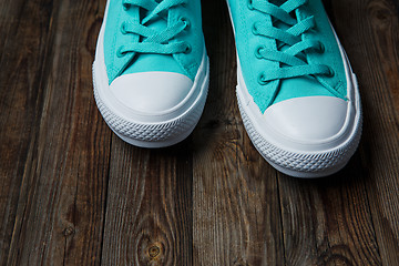 Image showing blue shoes over empty wooden floor