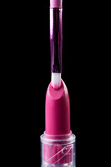 Image showing Tube of lipstick with a brush make-up on black 