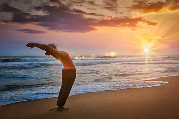 Image showing Young sporty fit man doing yoga Sun salutation Surya Namaskar