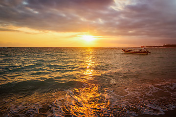 Image showing Calm ocean with boat on sunrise