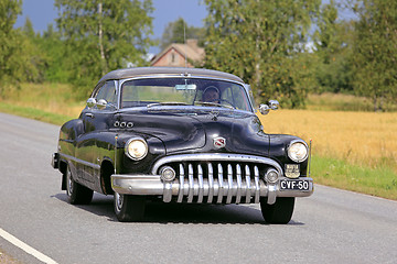 Image showing Black Buick Super Eight Classic Car Cruising Along Rural Road