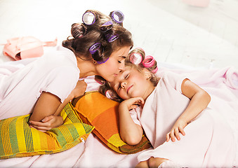 Image showing Little girl with her mother slipping in bed