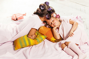 Image showing Little girl with her mother slipping in bed
