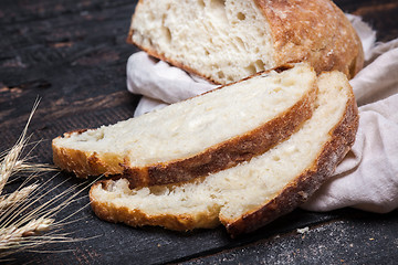 Image showing Rustic bread on wood table. Dark moody background with free text space.