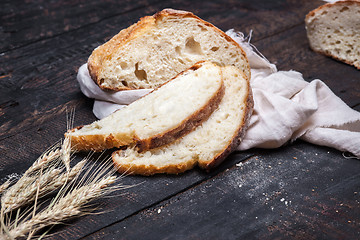 Image showing Rustic bread on wood table. Dark moody background with free text space.