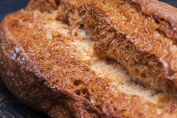 Image showing Rustic bread on wood table. Dark moody background with free text space.