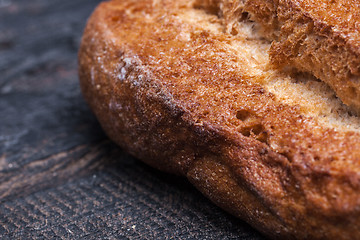 Image showing Rustic bread on wood table. Dark moody background with free text space.