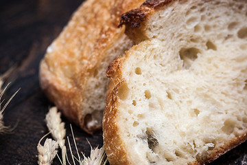 Image showing Rustic bread on wood table. Dark wooden background