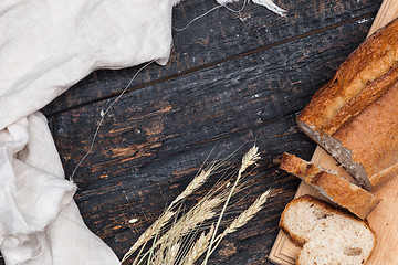 Image showing Rustic bread on wood table. Dark woody background with free text space.