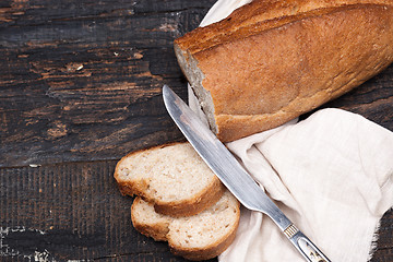 Image showing Rustic bread on wood table. Dark woody background with free text space.