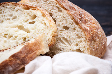 Image showing Rustic bread on wood table. Dark wooden background