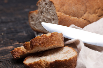 Image showing Rustic bread on wood table. Dark woody background with free text space.