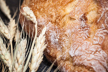 Image showing Rustic bread on wood table. Dark wooden background