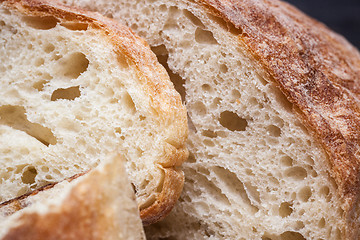 Image showing Rustic bread on wood table. Dark wooden background