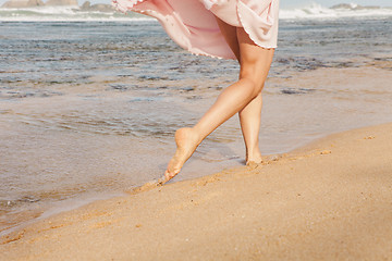 Image showing The young woman running on the beach