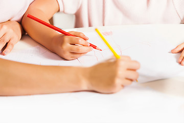 Image showing The young mother and her little daughter drawing with pencils at home