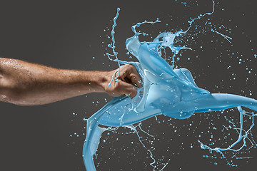 Image showing Close-up of a man\'s fist punching through liquid